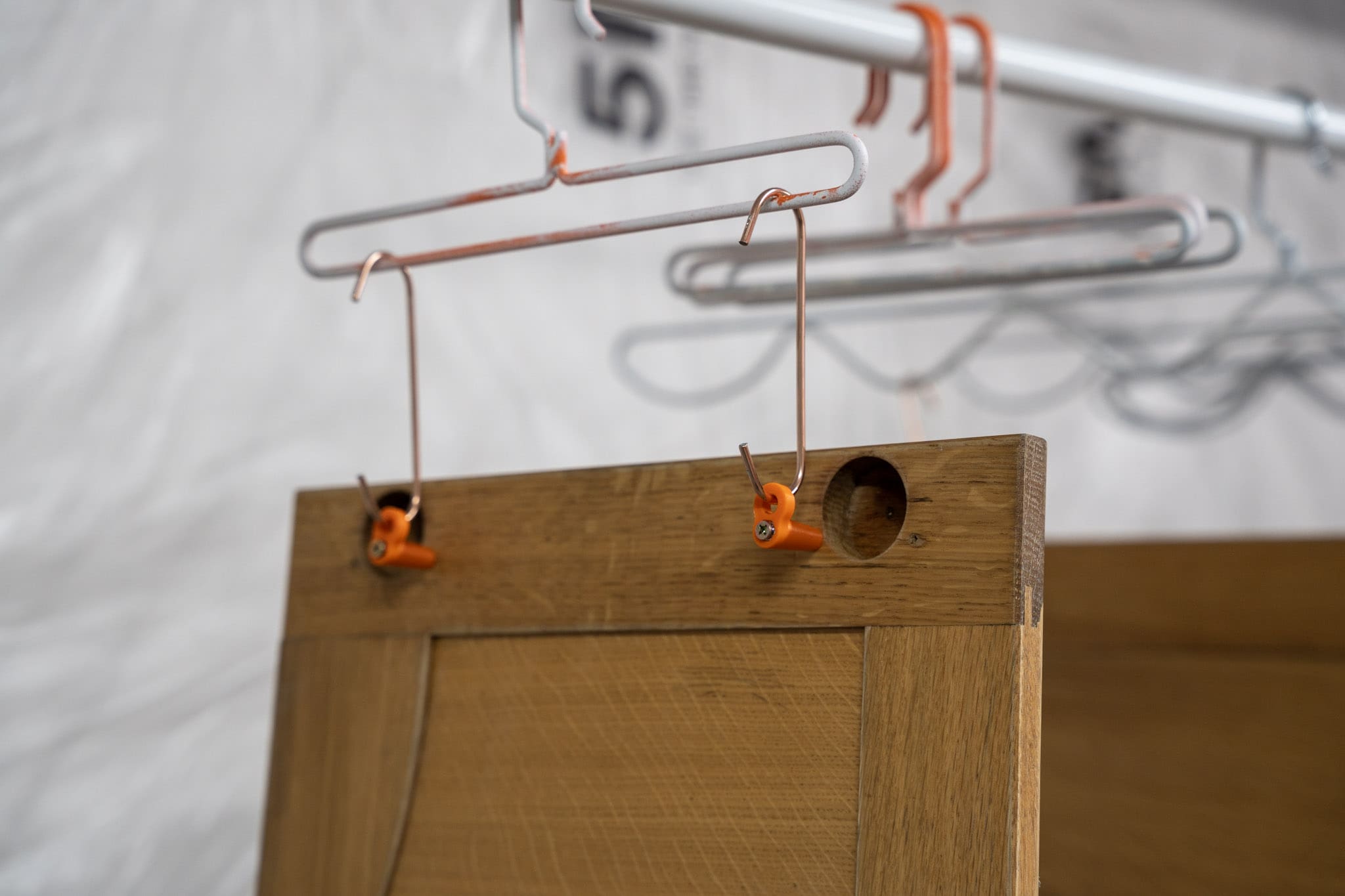 Angled cabinet door hanging system for easier spraying and better edge coverage