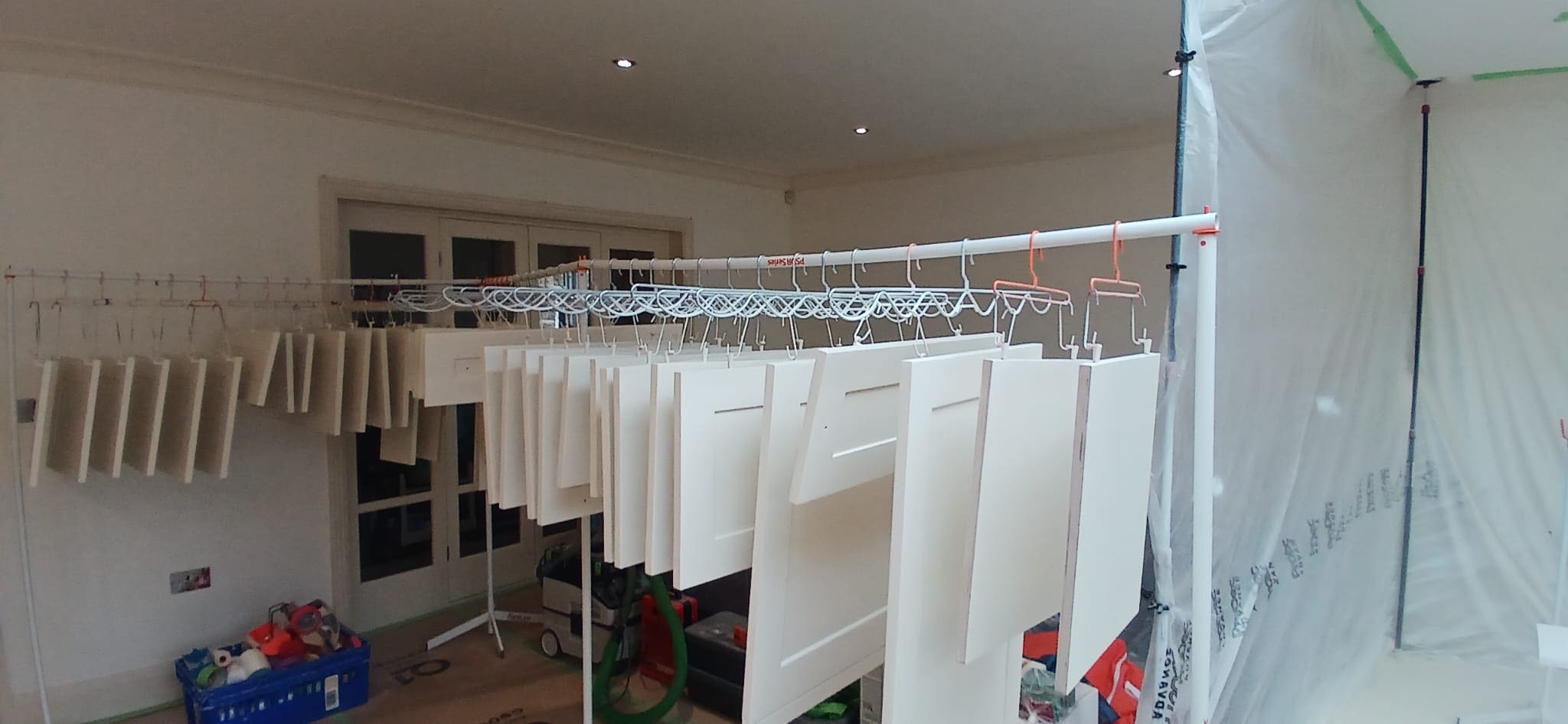 Cabinet doors hanging with the Spray Dogz system during a professional refinishing project